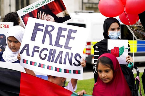 Demonstrators hold placards, during a protest in Parliament Square, London (Photo | AP)