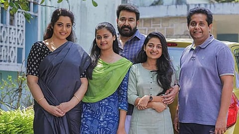 A still from 'Drishyam 2' starring  Mohanlal and Meena in the lead roles along with filmmaker Jeethu Joseph.