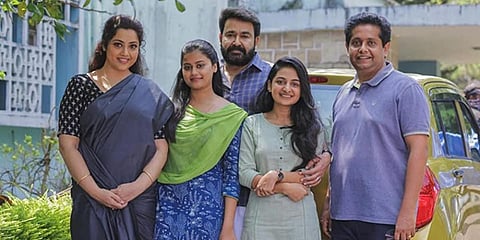 A still from 'Drishyam 2' starring  Mohanlal and Meena in the lead roles along with filmmaker Jeethu Joseph.