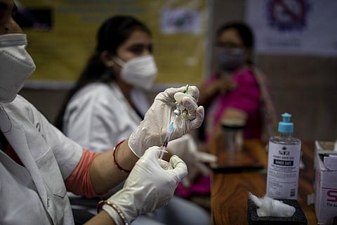 A health worker prepares to administer the Covishield vaccine to a woman at a government hospital. (File Photo | AP)