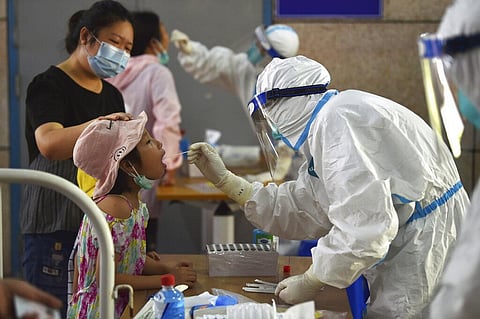 A nurse takes swab samples in the new rounds of Covid-19 testing in Nanjing in eastern China's Jiangsu province. (Photo. |AP)