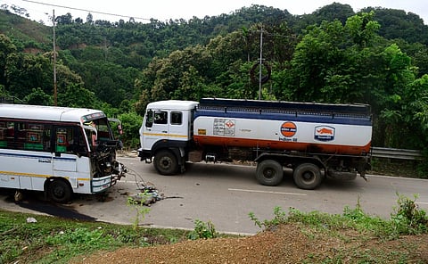 An oil tanker enters Mizoram, crossing a damaged bus below Mizoram Police outpost, on the outskirts of Vairengte.