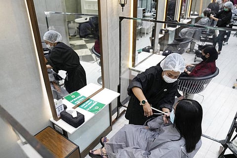 A barber cuts a customer's hair during the opening at the Paragon shopping mall in Bangkok, Thailand, Wednesday, Sept. 1, 2021. (Photo | AP)