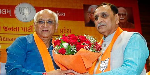 Former Gujarat Chief Minister Vijay Rupani felicitates the new Chief Minister Bhupendra Patel. (Photo | ANI)