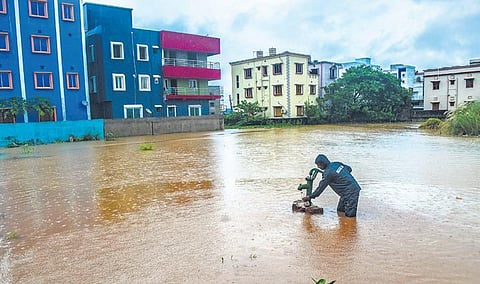 A man collects water from a submerged tubewell at Mahadev Nagar near Jharpada; the waterlogged WATCO plant at Basuaghai near Tankapani road in Bhubaneswar. 