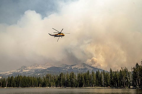 A helicopter flies over Wrights Lake while battling the Caldor Fire in Eldorado National Forest, Calif. on Wednesday, Sept. 1, 2021.  (Photo | AP)