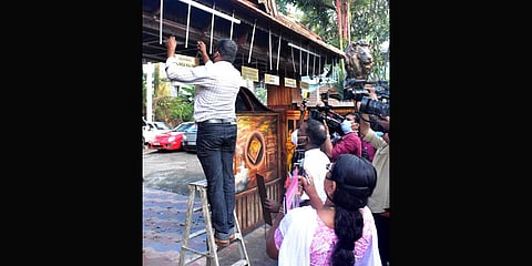 Crime Branch officials removing the nameboards put up in front of the house of  Monson Mavunkal. (Photo | Special Arrangement)