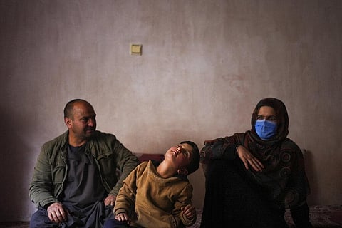 Sanam, a bacha posh, a girl living as a boy, sits next to her mother and father during an interview in their house, in Kabul, Afghanistan, Dec. 7, 2021.  (Photo | AP)