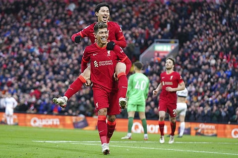 Liverpool's Takumi Minamino, top, celebrates with Liverpool's Roberto Firmino after scoring his side's third goal during an English Premier League soccer match between Liverpool and Brentford. (AP)
