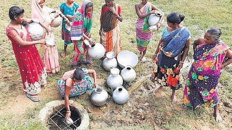 Women collecting water from a lone pit on the outskirts of Baidali village. (Photo| EPS)