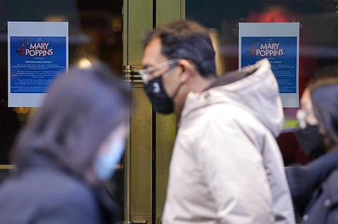 Pedestrians wearing masks against the coronavirus walk past a theater that has cancelled is performances due to COVID-19, in London. (Photo | AP)