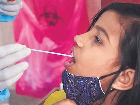 A health worker takes a swab sample of a woman in Bengaluru on Sunday. (Photo| Ashishkrishna H P)