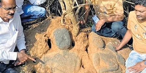 Archaeologists and history enthusiasts remove  the bushes grown on the sculptures