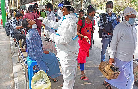 A health worker collects swab samples from passengers at a bus stand in Bengaluru  (File Photo | Vinod Kumar T, EPS)