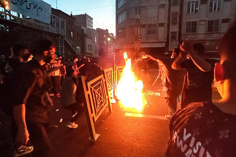 Protesters make fire and block the street during a protest over the death of a woman who was detained by the morality police, in downtown Tehran. (File Photo | AP)