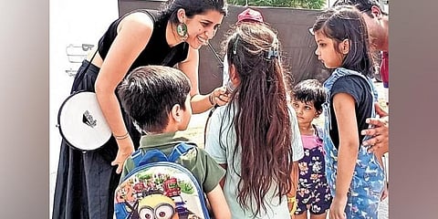 Alma interacting with the children; (below) a child painting  at the event