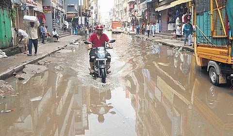A biker navigates through a waterlogged road at Sultanpet in Bengaluru following heavy downpour on Wednesday night