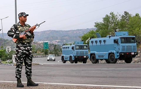 A CRPF personnel stands guard at the Jammu-Srinagar National Highway, in Jammu. (Photo | PTI)