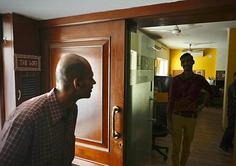 A visitor makes an enquiry standing outside the office of The Wire, an independent local news website, in New Delhi. (Photo | AP)