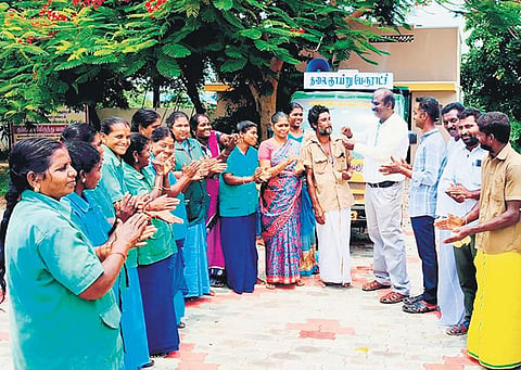 K Kuhan, executive officer of Thalaignayiru town panchayat, giving sweets to sanitary workers and celebrating the achievement on Monday | Express