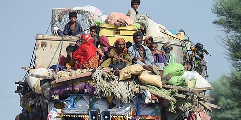 Displaced people sit on a tractor with their belongings as they make their way to reach  a safer place  after fleeing from their flood hit homes in Sindh.(File Photo | AFP)
