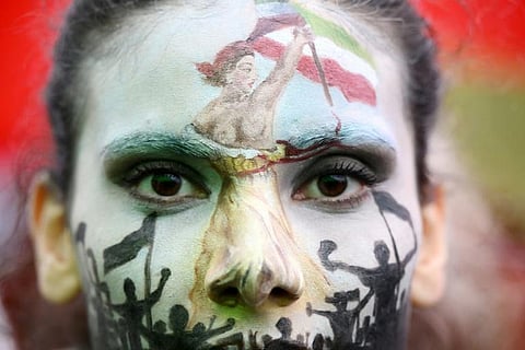 A woman wearing face-paint depicting France's iconic 'Marianne' leading an uprising demonstrates in Paris against Iran's bloody crackdown on women-led protests. (Photo | AFP)