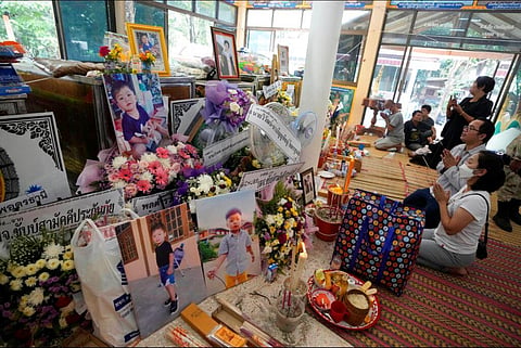 Relatives of the victims of a mass killing attack pray in front of photos and keepsakes at Wat Rat Samakee temple in the rural town of Uthai Sawan, north eastern Thailand. (Photo | AP)