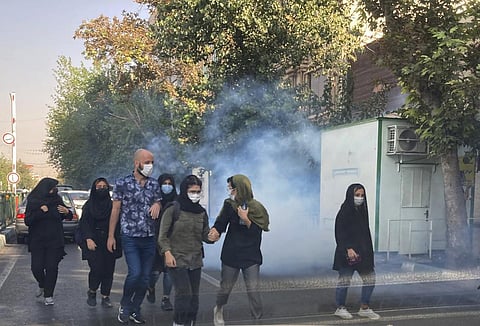 In this Oct 1, 2022, photo taken by an individual and obtained by the AP outside Iran, tear gas is fired by security to disperse protestors in front of the Tehran University. (Photo | AP)