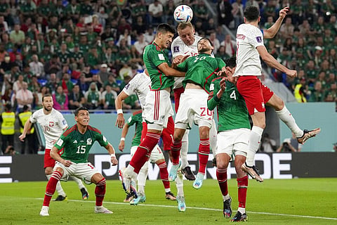 Poland's Kamil Glik and Mexico's Henry Martin (20) go for a header during a World Cup group C soccer match at the Stadium 974 in Doha, Qatar. (Photo | AP)