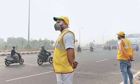 Civil defence volunteers wearing masks stand along a road in New Delhi.(File Photo)