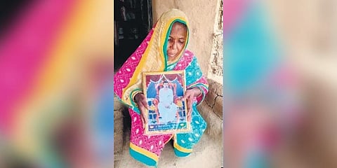 ​  Arati showing her husband’s photo  ​