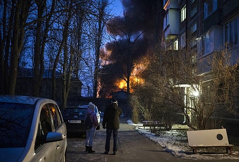 Residents watch at a burning infrastructure project hit during a massive Russian drone night strike in Kyiv, Ukraine | AP