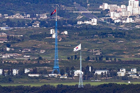 Flags of North Korea, rear, and South Korea, front, flutter in the wind as pictured from the border area between two Koreas in Paju, South Korea, on Aug. 9, 2021.  (File photo | AP)