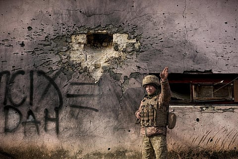 A Ukrainian serviceman points to incoming shelling next to a building which was hit by a large caliber mortar shell in Luhansk region, in eastern Ukraine, Saturday, Feb. 19, 2022. (Photo | AP)