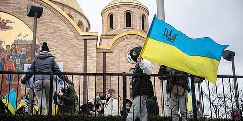 A protester holds a Ukrainian flag during a rally in response to Russia's invasion of Ukraine outside Saints Volodymyr.