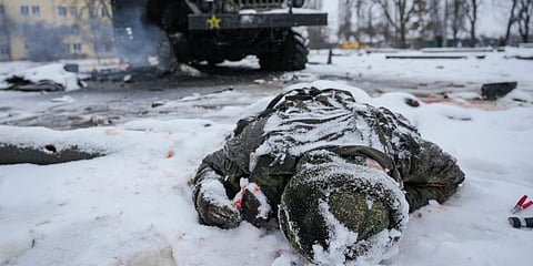 The body of a serviceman is coated in snow next to a destroyed Russian military multiple rocket launcher vehicle on the outskirts of Kharkiv, Ukraine. (Photo | AP)