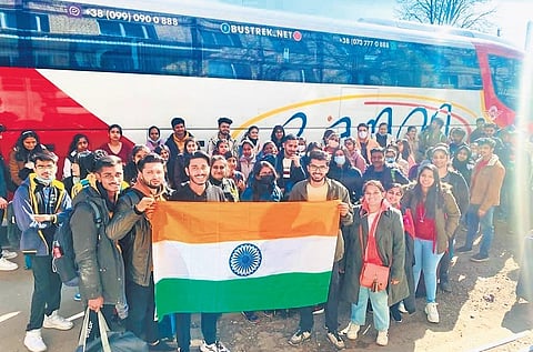 Indian students hold up the National flag as they are escorted from Ukraine to the Romanian border on Friday
