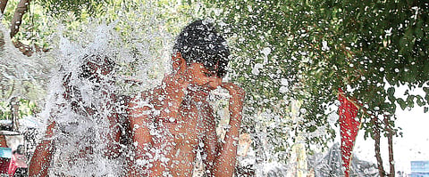 A young boy beats the heat at a tubewell on a hot Saturday in New Delhi