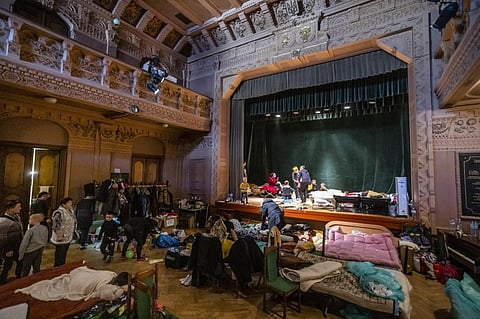 Ukrainian refugees are seen at the theatre of the Ukrainian House where a shelter for refugees is installed in Przemysl, southeastern Poland, near the Ukrainian-Polish border, on March 18, 2022. (AFP)