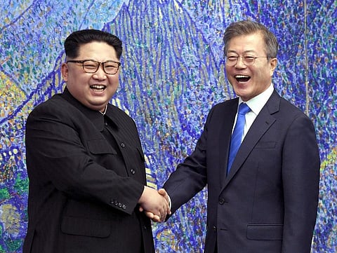 North Korean leader Kim Jong Un, left, poses with South Korean President Moon Jae-in for a photo inside the Peace House. (Photo | AP)
