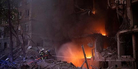 Firefighters try to put out a fire following an explosion in Kyiv, Ukraine. (Photo | AP)