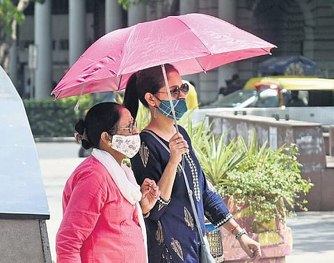 Women use umbrellas to protect themselves from the sun on a hot  summer day on Rajpath on Sunday | Parveen Negi