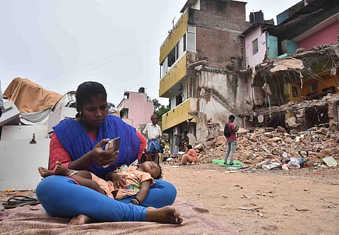 A child sleeps blissfully on lap of a woman whose house was along those demolished at Govindasamy Nagar, Chennai. (Photo | P Jawahar, EPS)