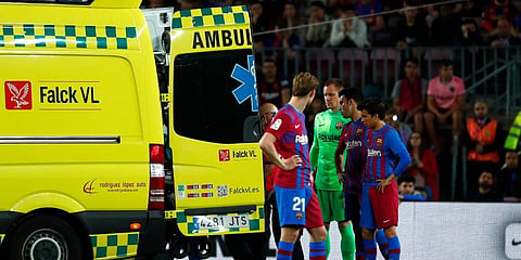 Barcelona players react as their teammate Ronald Araujo is carried by an ambulance after an injury during the Spanish La Liga match against Celta Vigo at the Camp Nou Stadium. (Photo | AP)