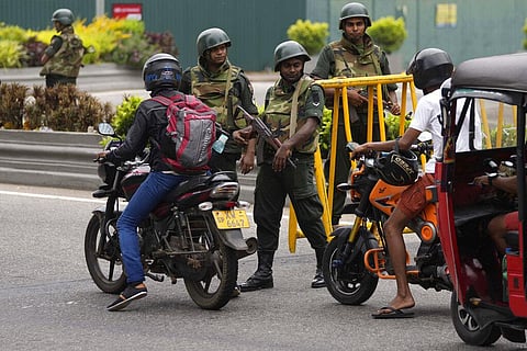 Sri Lankan army soldiers stand guard as motorists cross a checkpoint outside prime minister's residence a day after clashes between government supporters and anti-government protesters. (Photo | AP)