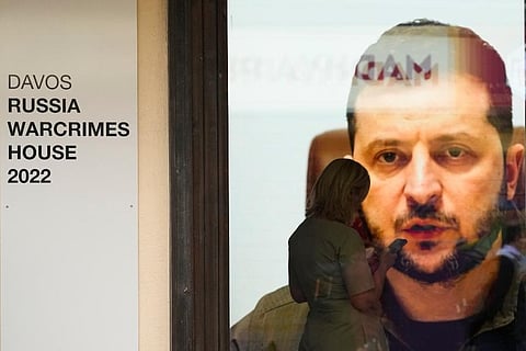 Ukrainian President Volodymyr Zelenskyy speaks on a screen inside a so-called Russian War Crimes House alongside the World Economy Forum in Davos. (Photo | AP)
