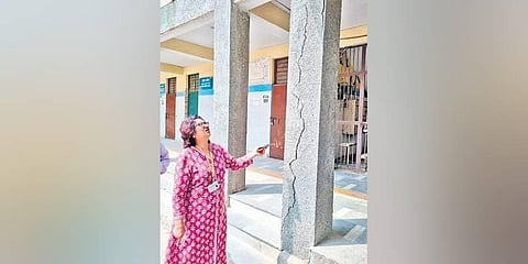 A DCPCR official checks a crack on a pillar at a school | Express
