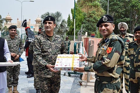 BSF and Pakistan Rangers exchange sweets on the occasion of Eid at Joint Check Post at Hussainiwala in Punjab on Tuesday. (Photo | ANI Twitter)