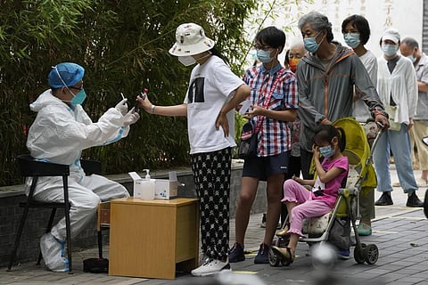 Residents line up for mass COVID tests. (Photo | AP)