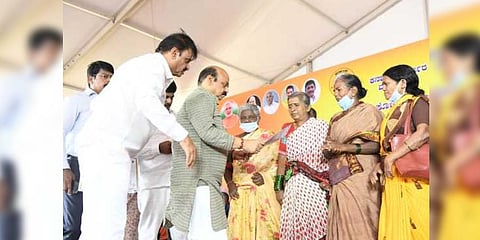 Chief Minister Basavaraj Bommai hands over a certificate to a woman  during his inspection of development works in the city | Express